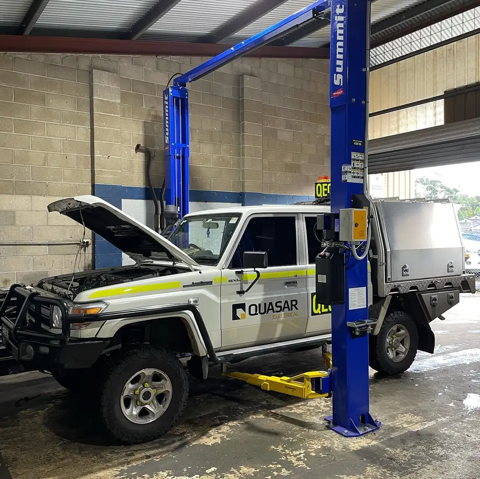 Utility vehicle on a hoist inside a mechanical workshop