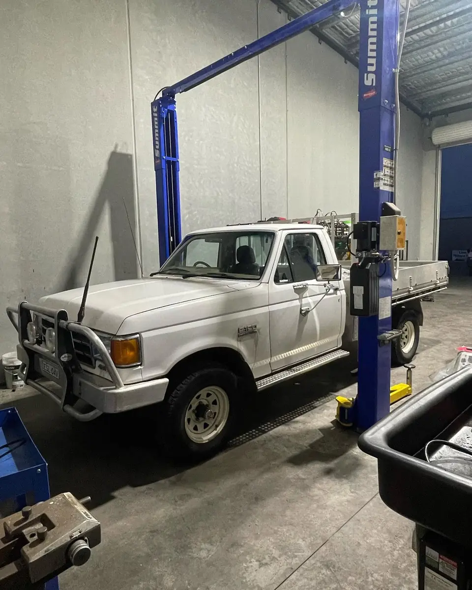 Utility vehicle positioned beside a workshop hoist